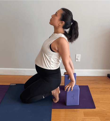alt="pregnant woman doing yoga poses while sitting"